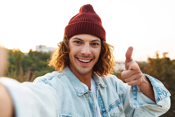 Obraz Uśmiechniętego Młodego Kręconego Mężczyzny Spacerującego Ulicą Robiącego Selfie Przed — Zdjęcie stockowe