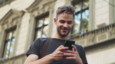 Sokakta cep telefonu kullanan iyimser bir genç.