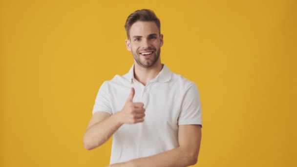 Knappe Jonge Vrolijke Man Poseren Geïsoleerd Gele Muur Achtergrond Tonen — Stockvideo