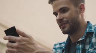 Sokakta cep telefonu kullanan iyimser bir genç.