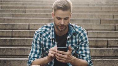 Sokakta cep telefonu kullanan yakışıklı bir adam.