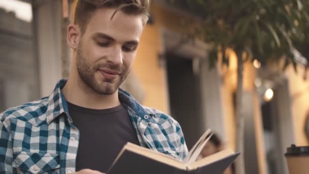 Веселый Улыбающийся Молодой Человек Читающий Книгу Улице — стоковое видео