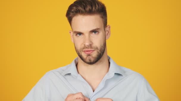 Calm Young Man Buttons His Shirt Standing Isolated Yellow Background — Stock Video