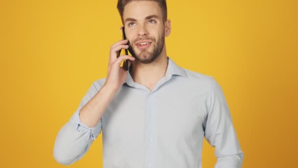 Joven Positivo Está Hablando Teléfono Inteligente Pie Aislado Sobre Fondo — Vídeo de stock