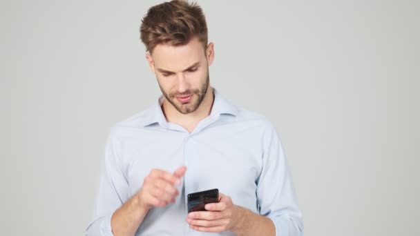 Tänkande Ung Affärsman Chattar Med Sin Smartphone Stående Isolerad Över — Stockvideo