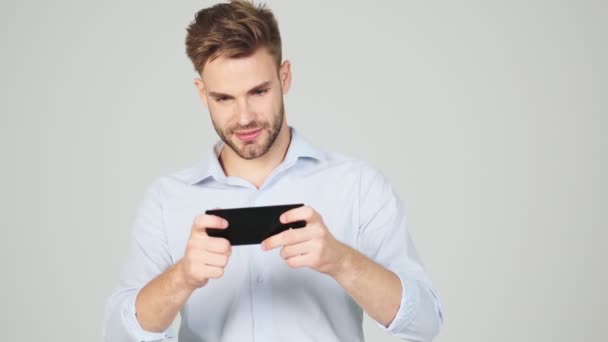 Glad Ung Affärsman Spelar Med Sin Smartphone Stående Isolerad Över — Stockvideo