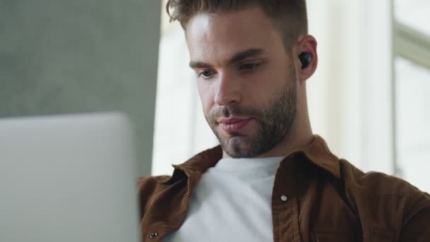 Beau Jeune Homme Avec Des Écouteurs Travaille Avec Son Ordinateur — Video