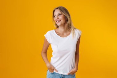 Mutlu, güzel bir kız gülümserken, sarı arka planda soyutlanmış bir kenara bakıyor.