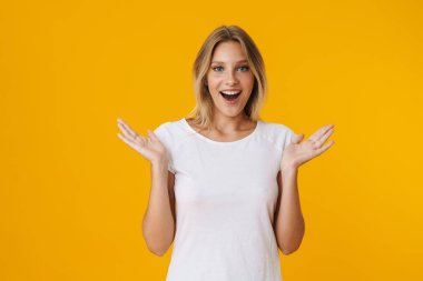 Heyecanlı güzel kız, sarı arka planda izole edilmiş elleri kustuğunu söylüyor.