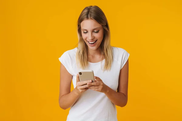 Podekscytowana Blondynka Uśmiechnięta Korzystająca Telefonu Komórkowego Żółtym Tle — Zdjęcie stockowe