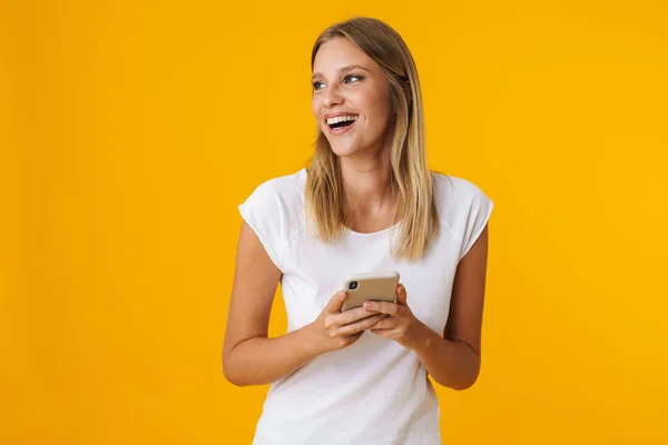 Excited Blonde Girl Smiling Using Mobile Phone Isolated Yellow Background — Stock Photo, Image