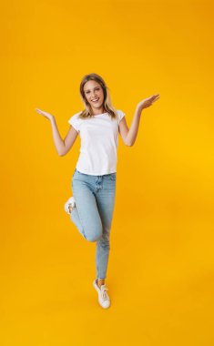 Sarı arka planda izole edilmiş telif alanı gösterirken gülümseyen mutlu güzel kız