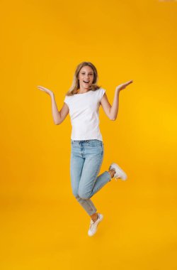 Sarı arka planda izole edilmiş telif alanı gösterirken gülümseyen güzel kız.