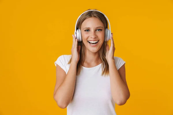 Wesoła Blondynka Uśmiechnięta Podczas Słuchania Muzyki Słuchawkami Odizolowanymi Żółtym Tle — Zdjęcie stockowe