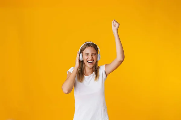 Χαρούμενη Ξανθιά Κοπέλα Ακουστικά Που Χορεύει Και Γελάει Απομονωμένη Κίτρινο — Φωτογραφία Αρχείου