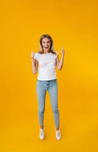 Garota Bonita Excitada Pulando Mostrando Polegares Isolados Sobre Fundo Amarelo — Fotografia de Stock