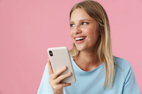 Uśmiechnięta Atrakcyjna Młoda Kobieta Korzystająca Telefonu Komórkowego Stojąca Różowym Tle — Zdjęcie stockowe