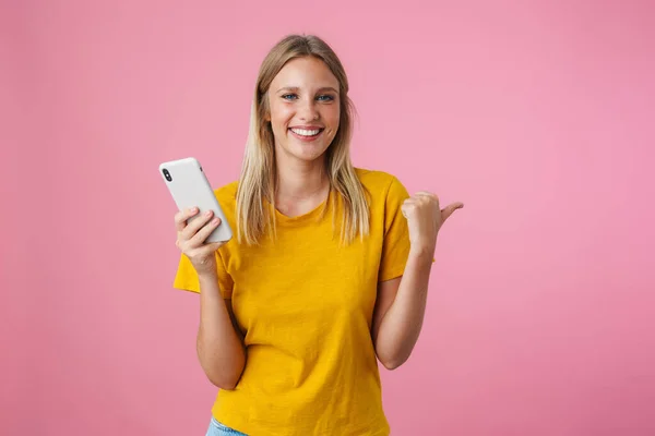 Vrolijk Blond Meisje Wijzend Vinger Opzij Met Behulp Van Mobiele — Stockfoto