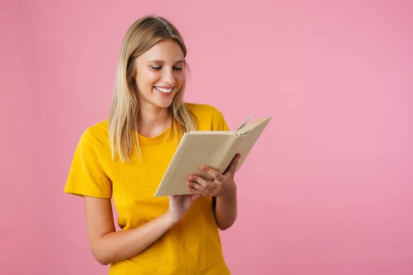 Wesoły Piękna Dziewczyna Uśmiechnięta Podczas Czytania Książki Izolowane Różowym Tle — Zdjęcie stockowe