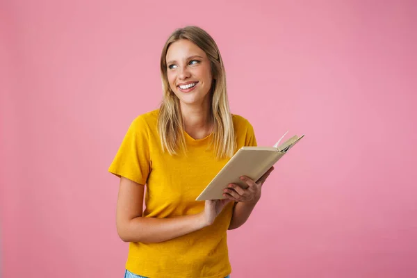 Vrolijk Mooi Meisje Glimlachen Tijdens Het Lezen Boek Geïsoleerd Roze — Stockfoto