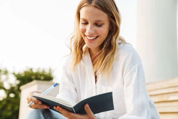 Hermosa Chica Estudiante Feliz Escribiendo Notas Libro Ejercicios Mientras Está —  Fotos de Stock