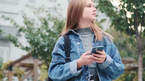 Eine Schöne Junge Frau Sucht Etwas Während Sie Ihr Smartphone — Stockvideo