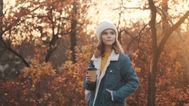 Piękna Młoda Blondynka Spaceruje Trzymając Filiżankę Herbaty Parku Zewnątrz — Wideo stockowe