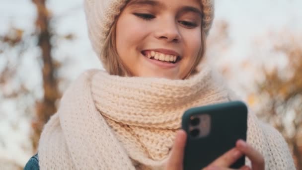 Mutlu Bir Genç Kız Parkın Dışında Akıllı Telefonunu Kullanıyor — Stok video