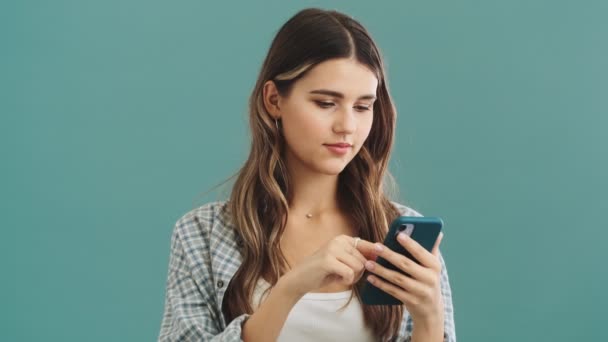 Een Tevreden Vrouw Kiest Iets Tijdens Het Typen Haar Smartphone — Stockvideo