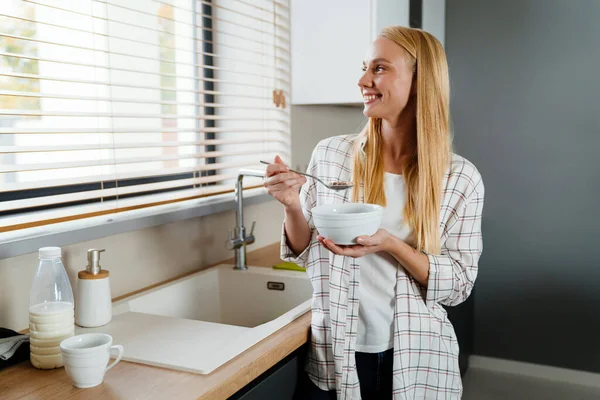 Hermosa Rubia Feliz Mujer Comiendo Cereal Mientras Desayuna Casa Cocina — Foto de Stock