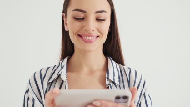 Усміхнена Жінка Використовує Свій Смартфон Тримаючи Його Горизонтально Стоячи Ізольовано — стокове відео