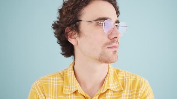 Hombre Sonriente Con Gafas Posando Aislado Sobre Una Pared Azul — Vídeos de Stock