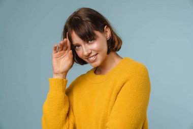 Mavi arka planda soyutlanmış mutlu, güzel bir kadın.