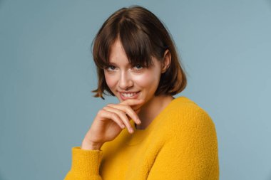 Mavi arka planda soyutlanmış mutlu, güzel bir kadın.