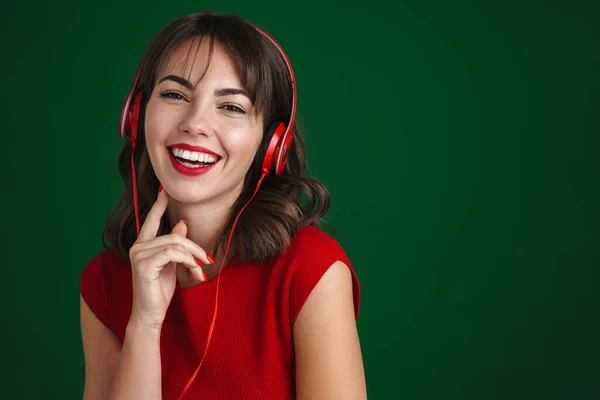 Piękny Szczęśliwy Brunetka Dziewczyna Słuchanie Muzyki Słuchawkami Izolowane Zielonym Tle — Zdjęcie stockowe