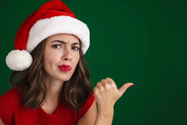 Vacker Missnöjd Flicka Santa Claus Hatt Pekar Finger Sidan Isolerad — Stockfoto