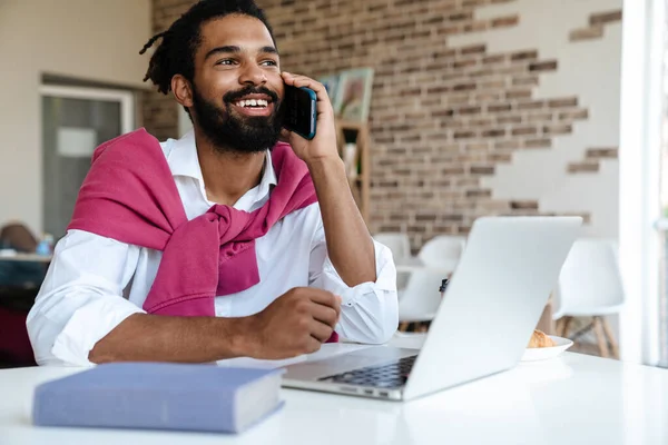 Usmívající Africký Američan Mluví Mobilu Pracuje Notebookem Kanceláři — Stock fotografie