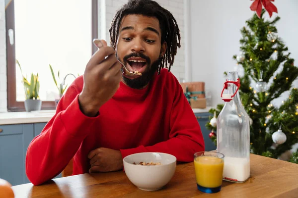 Vidám Afro Amerikai Férfi Eszik Gabona Miközben Reggelizik Hangulatos Konyhában — Stock Fotó