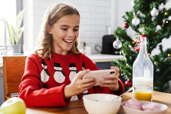 Feliz Chica Caucásica Jugando Videojuego Teléfono Móvil Mientras Desayuna Cocina —  Fotos de Stock