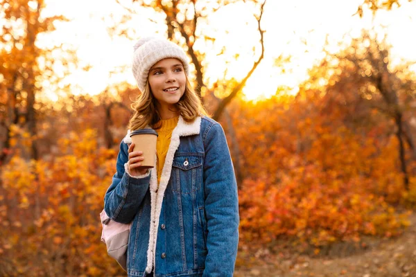 Obraz Młodej Wesołej Dziewczyny Siedzącej Świeżym Powietrzu Jesiennym Parku Pijącej — Zdjęcie stockowe