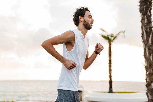 Concentrato Unshaven Ragazzo Esecuzione Mentre Allena Sul Lungomare — Foto Stock