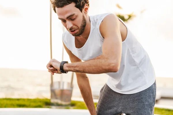 Concentrato Ragazzo Unshaven Guardando Orologio Polso Mentre Allena Sul Lungomare — Foto Stock