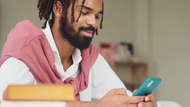 Positiv Afrikansk Amerikansk Man Använder Sin Smartphone Sitter Kontoret — Stockvideo
