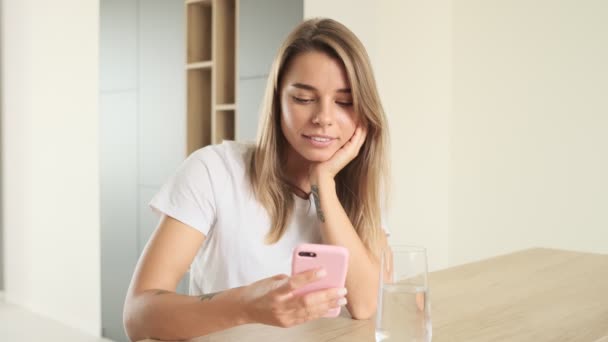 Vacker Kvinna Använder Sin Smartphone Sittandes Vid Bordet Hemma — Stockvideo