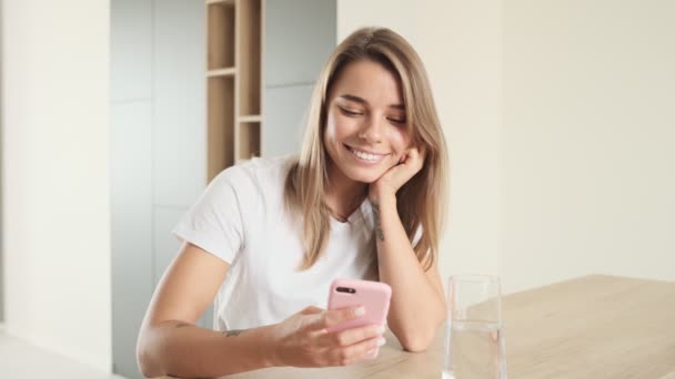 Nöjd Kvinna Använder Sin Smartphone När Hon Sitter Vid Bordet — Stockvideo