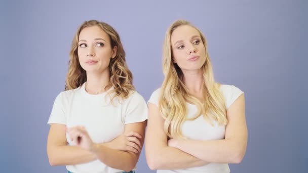 Dos Mujeres Atractivas Están Poniendo Pie Aislado Sobre Fondo Azul — Vídeo de stock