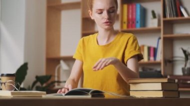 Ciddi bir kızıl saçlı kadın ofiste masada oturuyor.