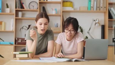 Güzel kadın iş arkadaşları ofiste kağıtlarla çalışırken projeleri tartışıyorlar.