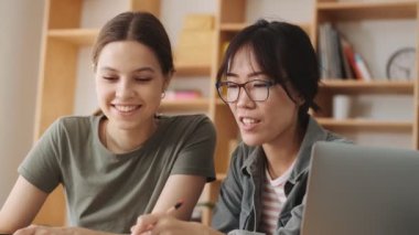 Güzel kadın çalışanlar ofiste kağıtlarla çalışırken projeleri tartışıyorlar.