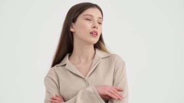 Yakışıklı genç bir kadın stüdyoda beyaz arka planda izole edilmiş bir şey düşünüyor.